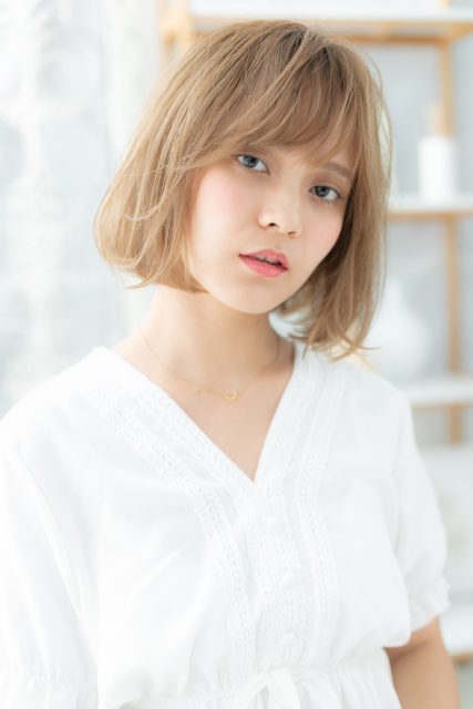 斜めバング×ミルキーベージュ前下がりボブ